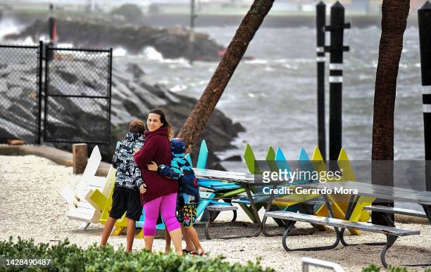 Local residents walk in the middle of rain and heavy wind at the St. Pete pier as the Hurricane Ian hits the west coast on September 28, 2022 in St....