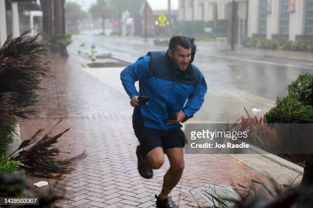 Brent Shaynore runs to a sheltered spot through the wind and rain from Hurricane Ian on September 28, 2022 in Sarasota, Florida. Ian made landfall...