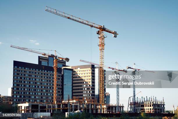 tower cranes and high-rise buildings silhouettes - building activity stock pictures, royalty-free photos & images