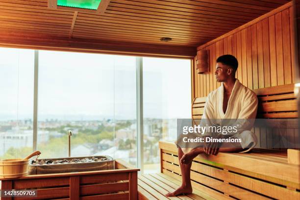 man enjoying view in sauna. - sauna stock pictures, royalty-free photos & images