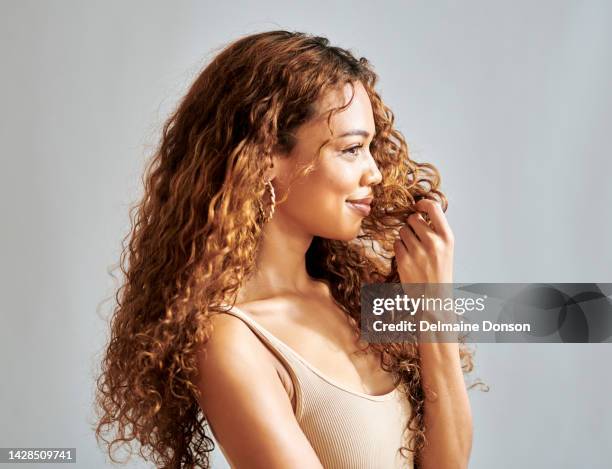 face of happy latino woman thinking and looking in the distance and relax at home. smile, carefree and happiness woman thoughtful and daydreaming about her life and future in a grey studio background - wavy brown hair stock pictures, royalty-free photos & images