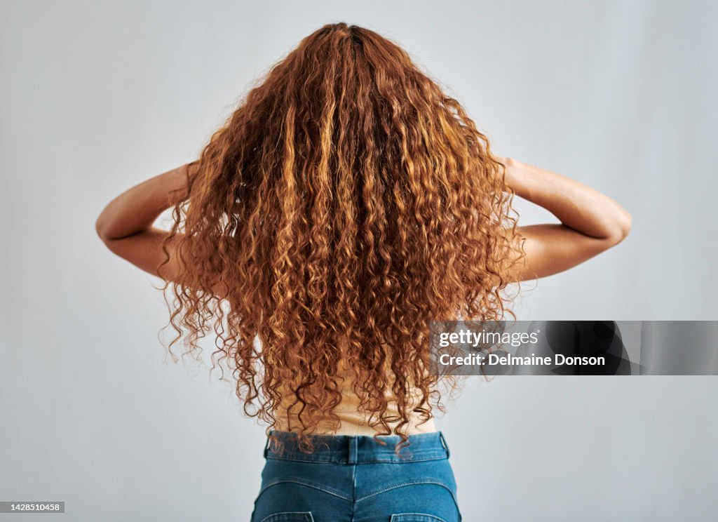 Mujer con cabello sano, natural y de jengibre con peinado relajado rizado, auburn o de belleza roja vista trasera. Champú salón de cuidado del cabello o chica pelirroja jugando con el cabello rojo limpio aislado sobre fondo gris