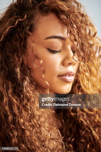 cuidados com o cabelo, cabelo encaracolado e modelo brasileira com produtos cosméticos no rosto em um estúdio. close-up de uma jovem, bonita e saudável mechas naturais de uma menina do brasil usando maquiagem. - weaving - fotografias e filmes do acervo