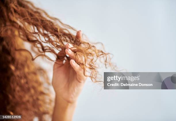 自然な、損傷した髪と巻き毛を持つ女性の肖像画。ヘアトリートメント、枝分かれ、乾燥した髪によるダメージを示すために指先を持つ女の子。健康な髪のためのヘア製品、ケアと修理 - hair products ストックフォトと画像