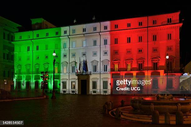 Italian tricolor flag projected on the illuminated facade of Chigi Palace, seat of the Presidency of the Council of Ministers. Rome, Italy, Europe,...