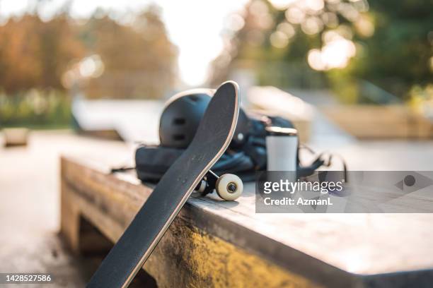 skateboard appoggiato alla scatola del marciapiede con tazza di caffè e casco sopra di esso - skate foto e immagini stock
