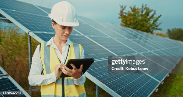 solar energy and electricity with a woman engineer, technician or contractor working on a tablet to install panels on a farm outside. renewable, innovation and sustainability with a female outdoor - low carbon technology stockfoto's en -beelden