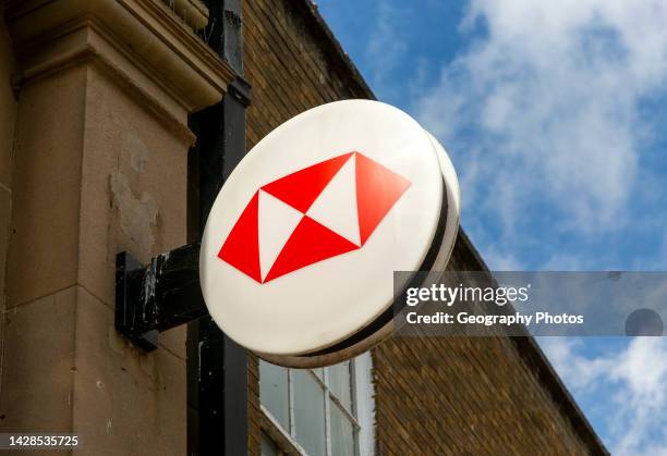 Wall hanging sign for HSBC bank branch on High Street, UK.