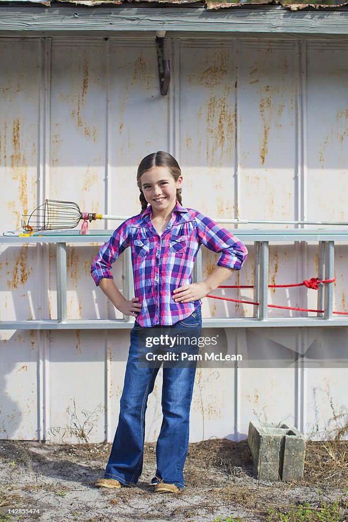 Young girl posing in front of a shed