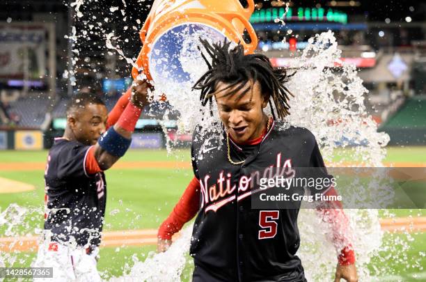 Abrams of the Washington Nationals gets doused with water by Victor Robles after driving in the game winning run with a single in the tenth inning...