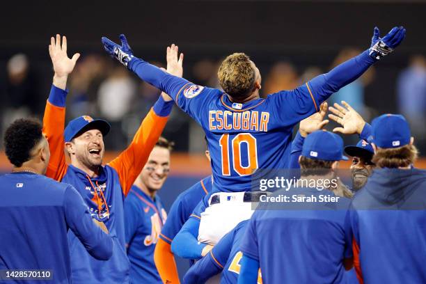 Eduardo Escobar reacts with Max Scherzer and New York Mets teammates after hitting a walk-off RBI single during the tenth inning against the Miami...