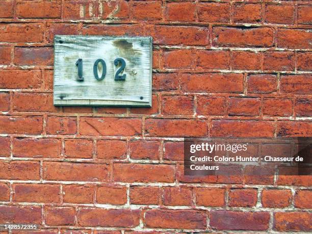 the number 102 on the weathered brick facade of a house in brussels, belgium - 2nd street stock pictures, royalty-free photos & images