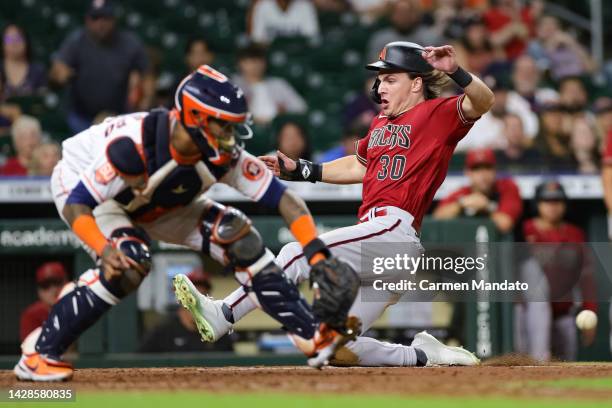 Jake McCarthy of the Arizona Diamondbacks scores ahead of Martin Maldonado of the Houston Astros on a single hit by Christian Walker during the tenth...