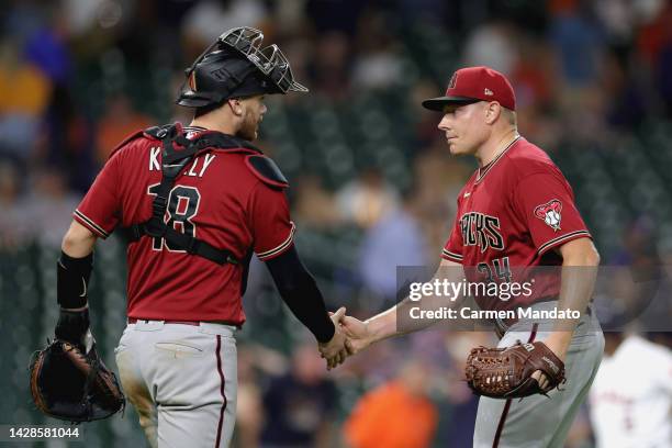 Mark Melancon of the Arizona Diamondbacks and Carson Kelly high five after defeating the Houston Astros in extra innings 5-2 at Minute Maid Park on...