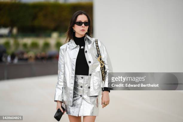 Guest wears black sunglasses, a black turtleneck pullover from Courreges, a silver shiny varnished leather jacket, a matching silver shiny varnished...