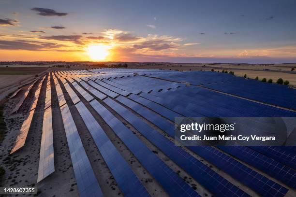 aerial view of the solar power plant with sunset reflection on the solar panels, renewable energy, solar energy - extremadura stockfoto's en -beelden