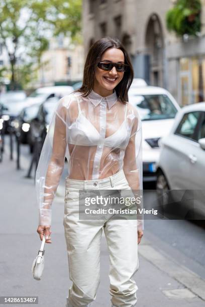 Mary Leest wears white see trough top, bra, pants, knee high boots, micro bag outside Cecilie Bahnsen during Paris Fashion Week - Womenswear...
