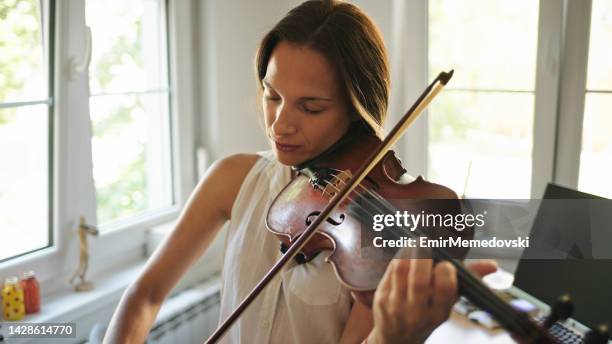 young female violinist practicing at home - beautiful woman violinist stock pictures, royalty-free photos & images