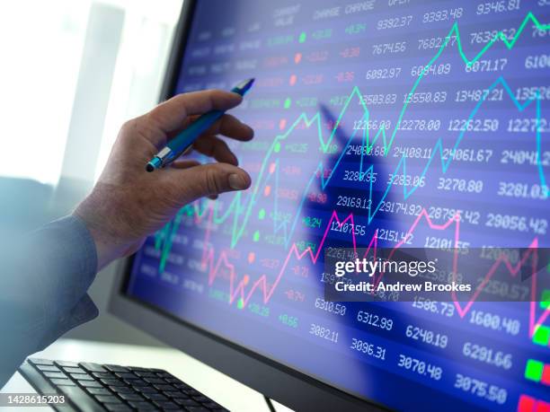 stock trader viewing performance of shares on screen - corretor de bolsa imagens e fotografias de stock