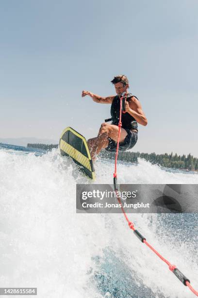 man wakeboarding at lake - wasserskifahren stock-fotos und bilder