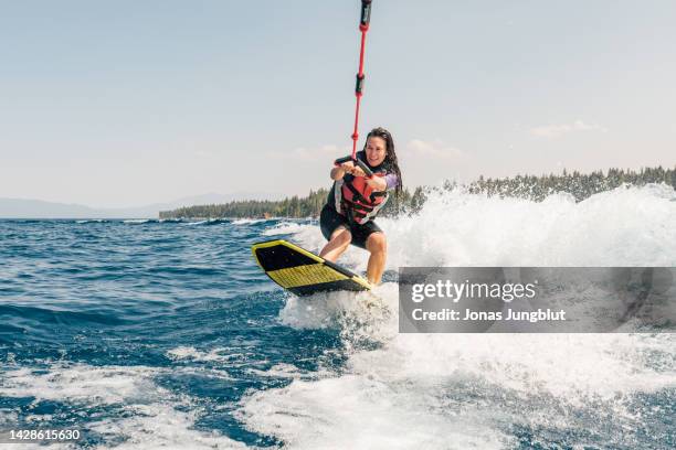 woman wakeboarding at lake - waterskiing - fotografias e filmes do acervo