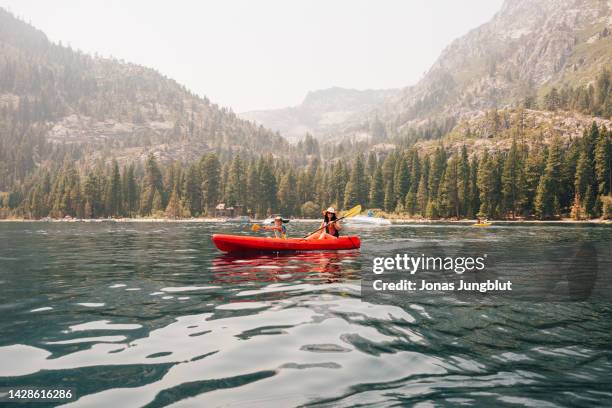 woman with daughter (7-8) in kayak at lake - lake tahoe stock pictures, royalty-free photos & images