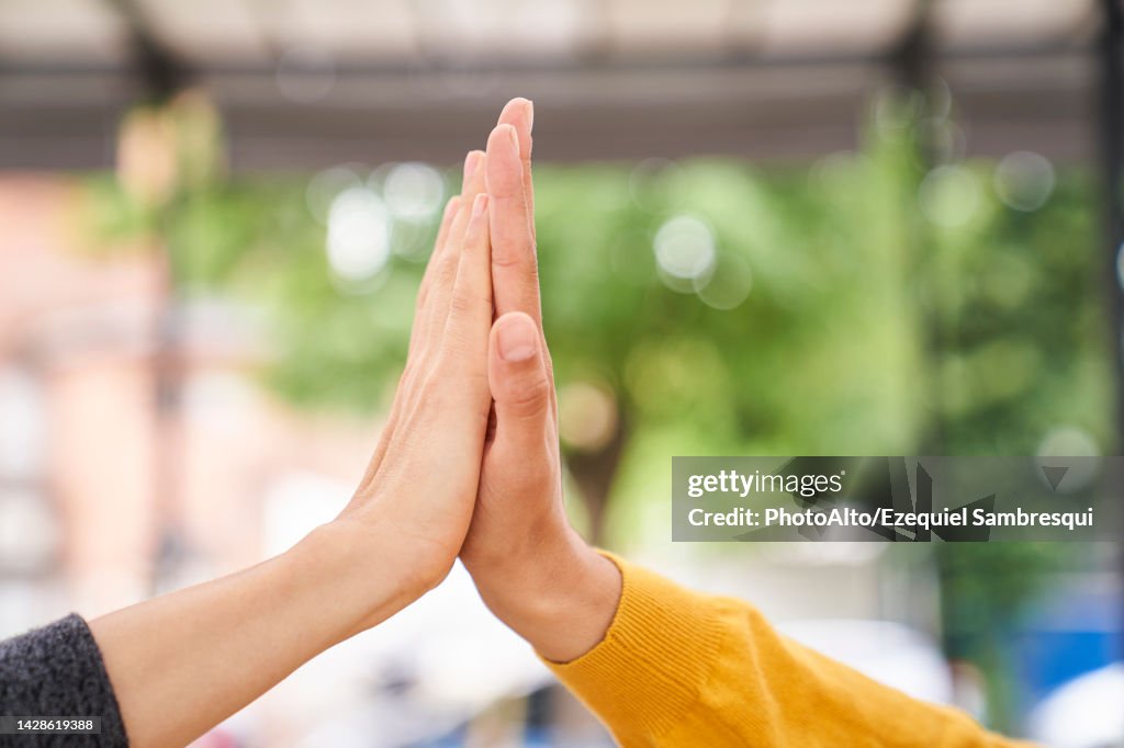 Close-up shot of women's hands high-fiving each other