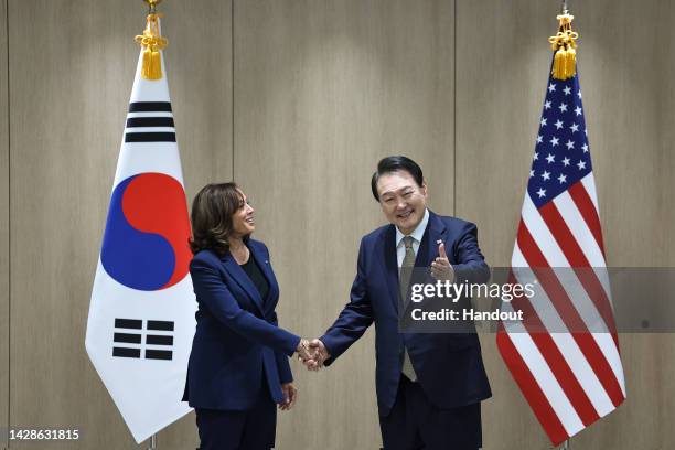 In this handout image provided by the South Korean Presidential Office, South Korean President Yoon Suk-yeol shakes hands with U.S. Vice President...