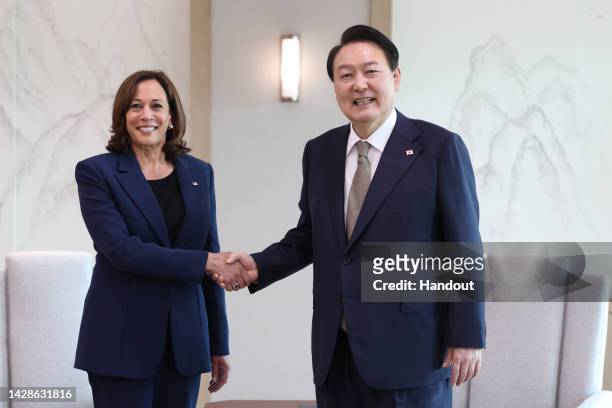 In this handout image provided by the South Korean Presidential Office, South Korean President Yoon Suk-yeol shakes hands with U.S. Vice President...