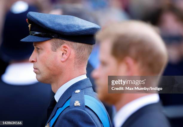 Prince William, Prince of Wales and Prince Harry, Duke of Sussex walk behind Queen Elizabeth II's coffin as it is transported on a gun carriage from...