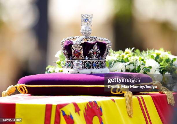 Queen Elizabeth II's coffin, draped in the Royal Standard and bearing the Imperial State Crown, is transported on a gun carriage from Buckingham...