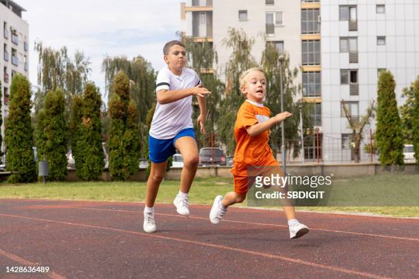 boys running on the track in the city. - european athletics stock pictures, royalty-free photos & images