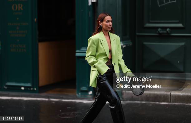 Alice Barbier is seen wearing a green neon blazer, black bralette and black leather pants and boots, outside Koche during Pariser Fashion Week on...