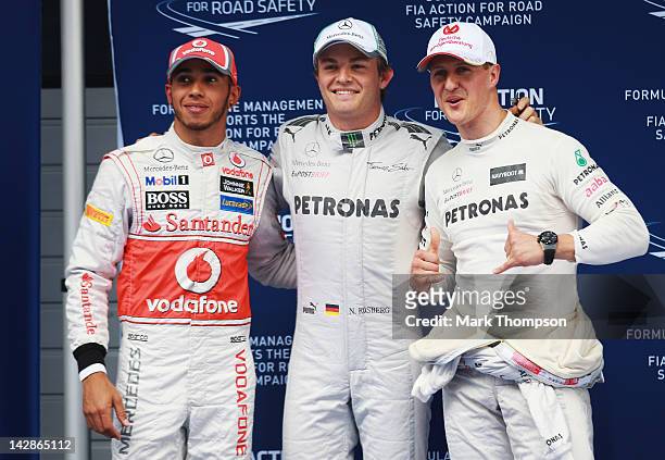 Polesitter Nico Rosberg of Germany and Mercedes GP celebrates with second placed Lewis Hamilton of Great Britain and McLaren and third placed Michael...