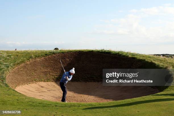 Rory McIlroy of Northern Ireland looks on as his father, Gerry McIlroy plays a shot from the spectacles bunker during Day One of the Alfred Dunhill...