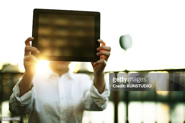 young business woman showing tablet pc - viso nascosto foto e immagini stock