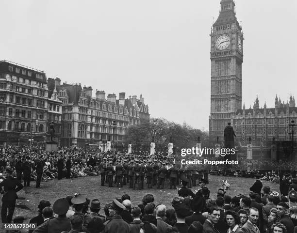 Large crowds gather in Parliament Square in front of the Palace of Westminster to listen to a military band playing as they celebrate Victory in...