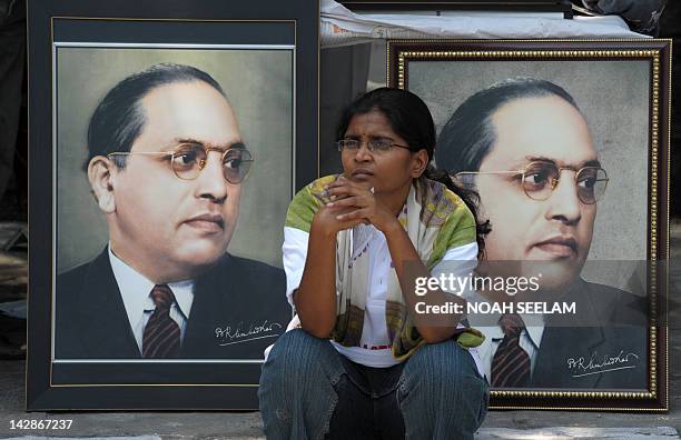 An Indian woman sits infront of portraits of Bhimrao Ramji Ambedkar during 122nd birth anniversary celebrations for Ambedkar in Hyderabad on April...