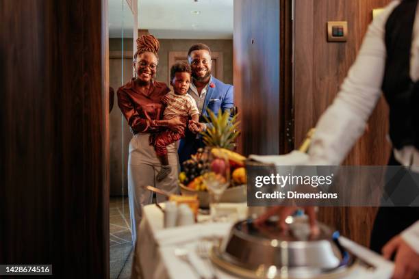 family on vacation orders room service. - roomservice stockfoto's en -beelden