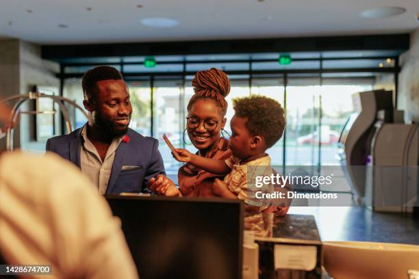 child and parents checking into hotel. - fashionable dad stock pictures, royalty-free photos & images