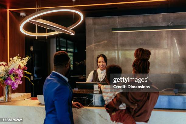 wealthy couple checks into hotel. - hotel occupation stock pictures, royalty-free photos & images