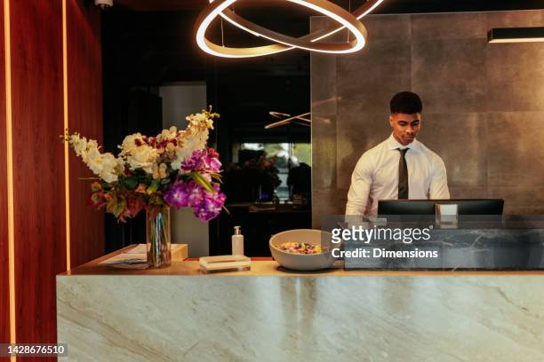 receptionist at front desk. - hospitality worker stockfoto's en -beelden