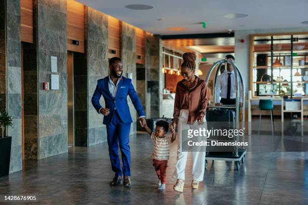familia que va a la habitación del hotel con equipaje. - african kids stylish fotografías e imágenes de stock