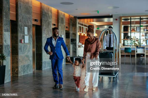 family going to hotel room with luggage. - luxury family stockfoto's en -beelden