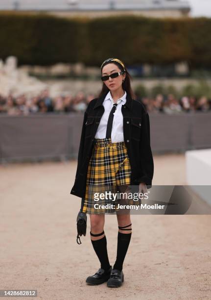 Chriselle Lim is seen wearing a yellow with black/white pattern Dior headband, a white button shirt, black tie, black oversized denim jacket, yellow...