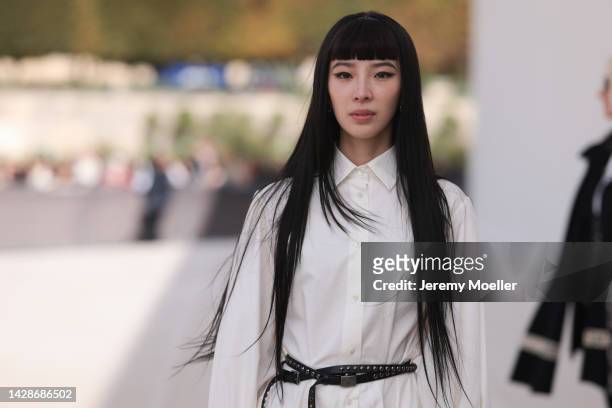 Irene Kim wears a white shirt midi dress with long sleeves from Dior and a black shiny leather studded Dior belt, outside Dior, during Paris Fashion...