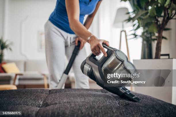 frau hausfrau staubsauger möbel in einem haus mit einem tragbaren staubsauger handgehalten - vacuum cleaner stock-fotos und bilder