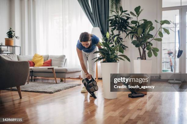 cleaning wooden floor with wireless vacuum cleaner - vacuum cleaner woman stockfoto's en -beelden