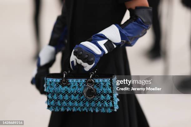 Yuwei Zhangzou is seen wearing a black long pleated dress from Dior, a black/blue/white shiny leather Dior high gloves and a black with embroidered...