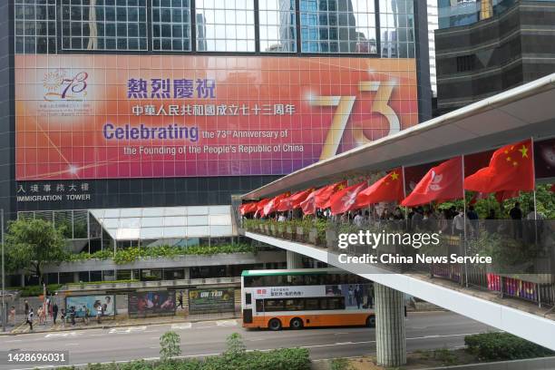 Pedestrians cross a footbridge decorated with Chinese national flags ahead of the China's National Day on September 29, 2022 in Hong Kong, China.